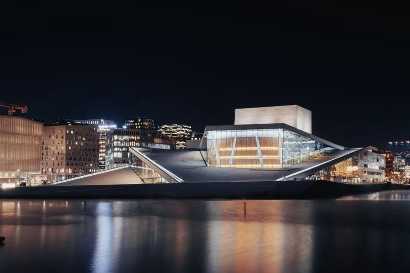 The Oslo opera house lit at night above the waterfront