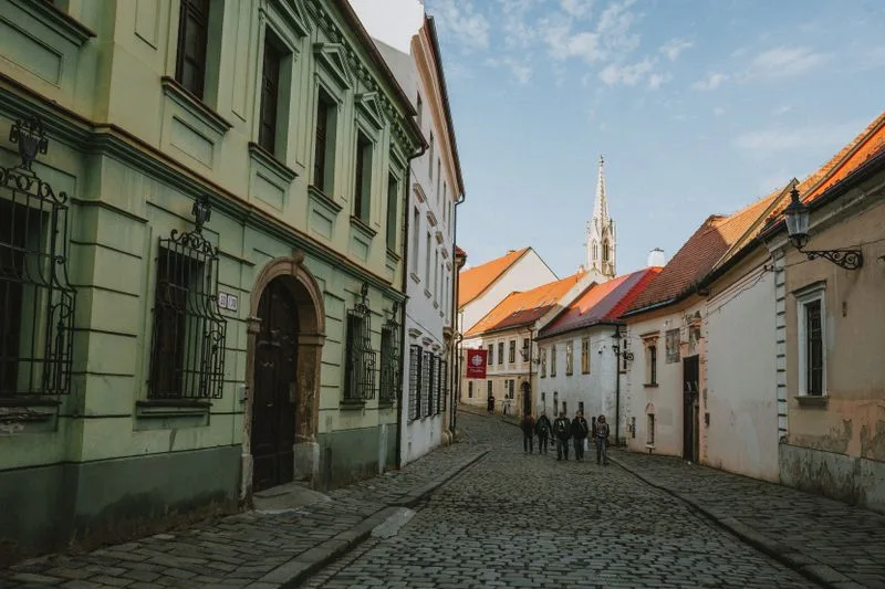 A cobbled lane in Bratislava old town below the spire of St Martin's Cathedral