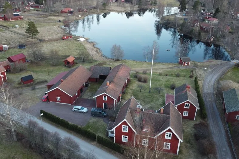 A red wooden farmhouse beside a lake in Dalarna